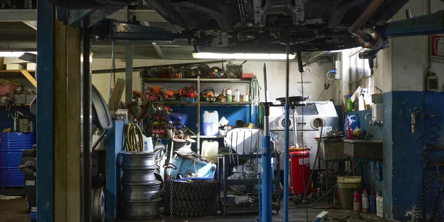 A car up on the hoist in a small independent workshop