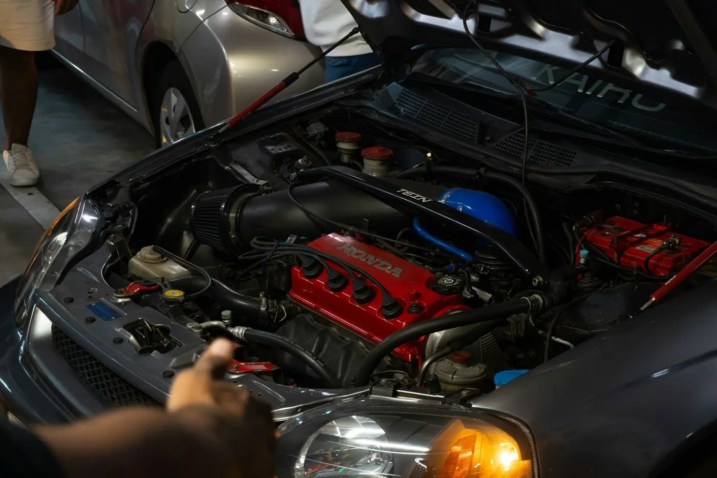 Hands working in an open engine bay during a service