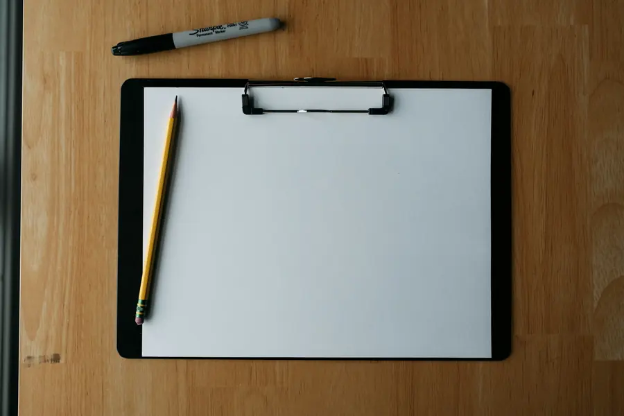 Clipboard and pen on a wooden bench